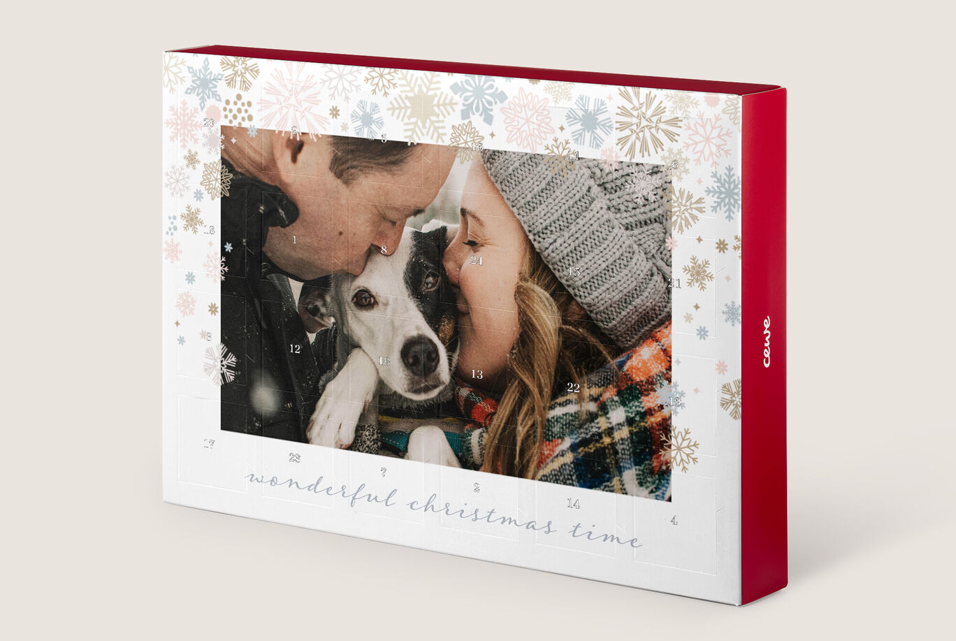 Een vrolijk persoon met een hond in de armen, omringd door feestelijke kerstdecoratie.